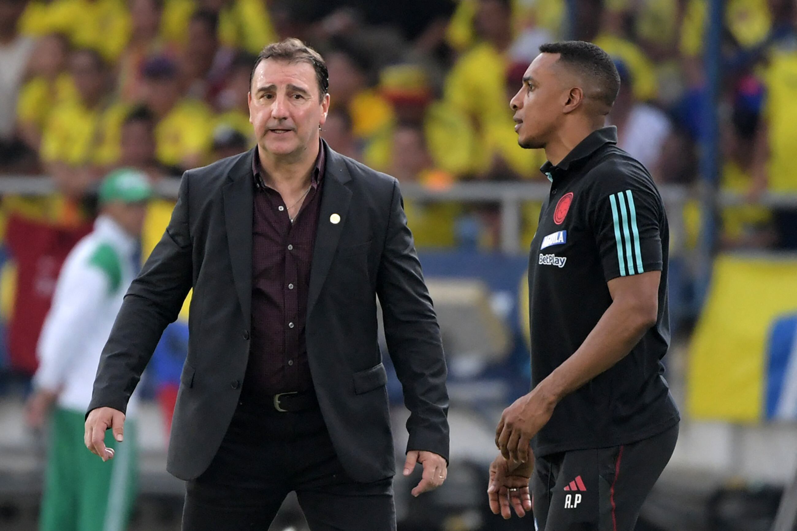 Colombia's Argentine coach Nestor Lorenzo (L) and Colombian assistant coach Luis Amaranto Perea give instructions to the players during the 2026 FIFA World Cup South American qualification football match between Colombia and Uruguay at the Roberto Melendez Metropolitan Stadium in Barranquilla, Colombia, on October 12, 2023. (Photo by Raul ARBOLEDA / AFP)