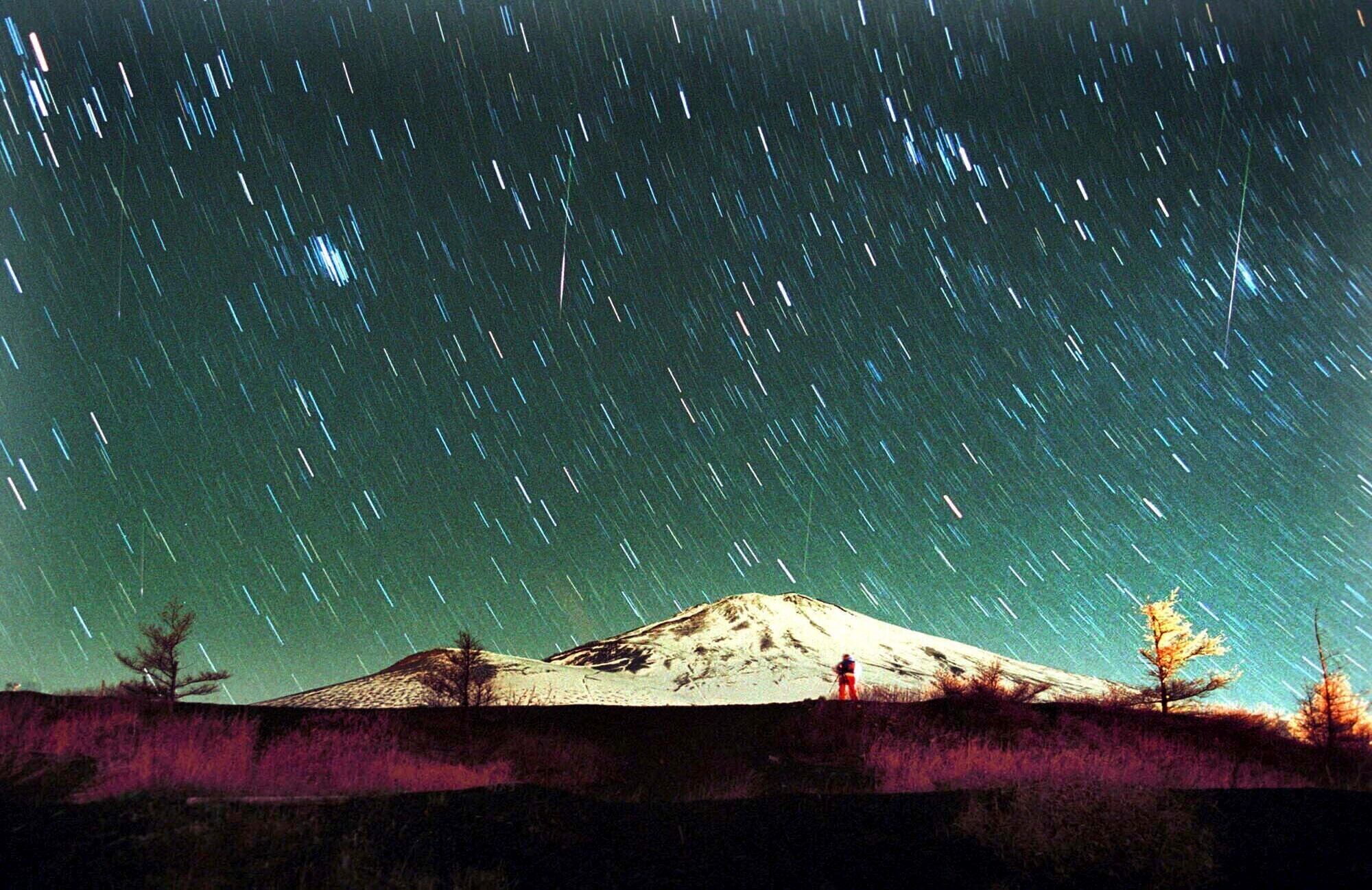 ARCHIVO - La lluvia de meteoritos Leónidas es vista en el cielo sobre el nevado Monte Fuji, la montaña más elevada de Japón, en esta imagen de 7 minutos tomada el 19 de noviembre de 2001. (AP Foto/Itsuo Inouye, archivo)