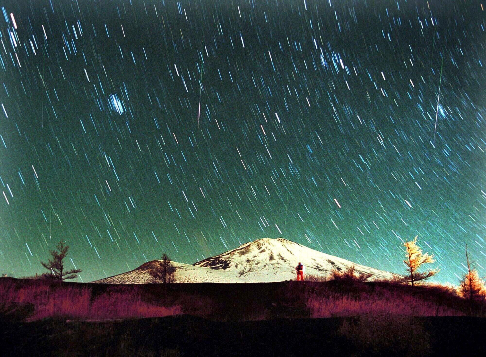ARCHIVO - La lluvia de meteoritos Leónidas es vista en el cielo sobre el nevado Monte Fuji, la montaña más elevada de Japón, en esta imagen de 7 minutos tomada el 19 de noviembre de 2001. (AP Foto/Itsuo Inouye, archivo)