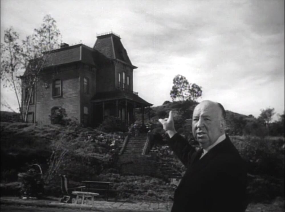 Alfred Hitchcock ante el motel de Psicosis, imagen perteneciente al tráiler oficial de la película. Wikimedia Commons