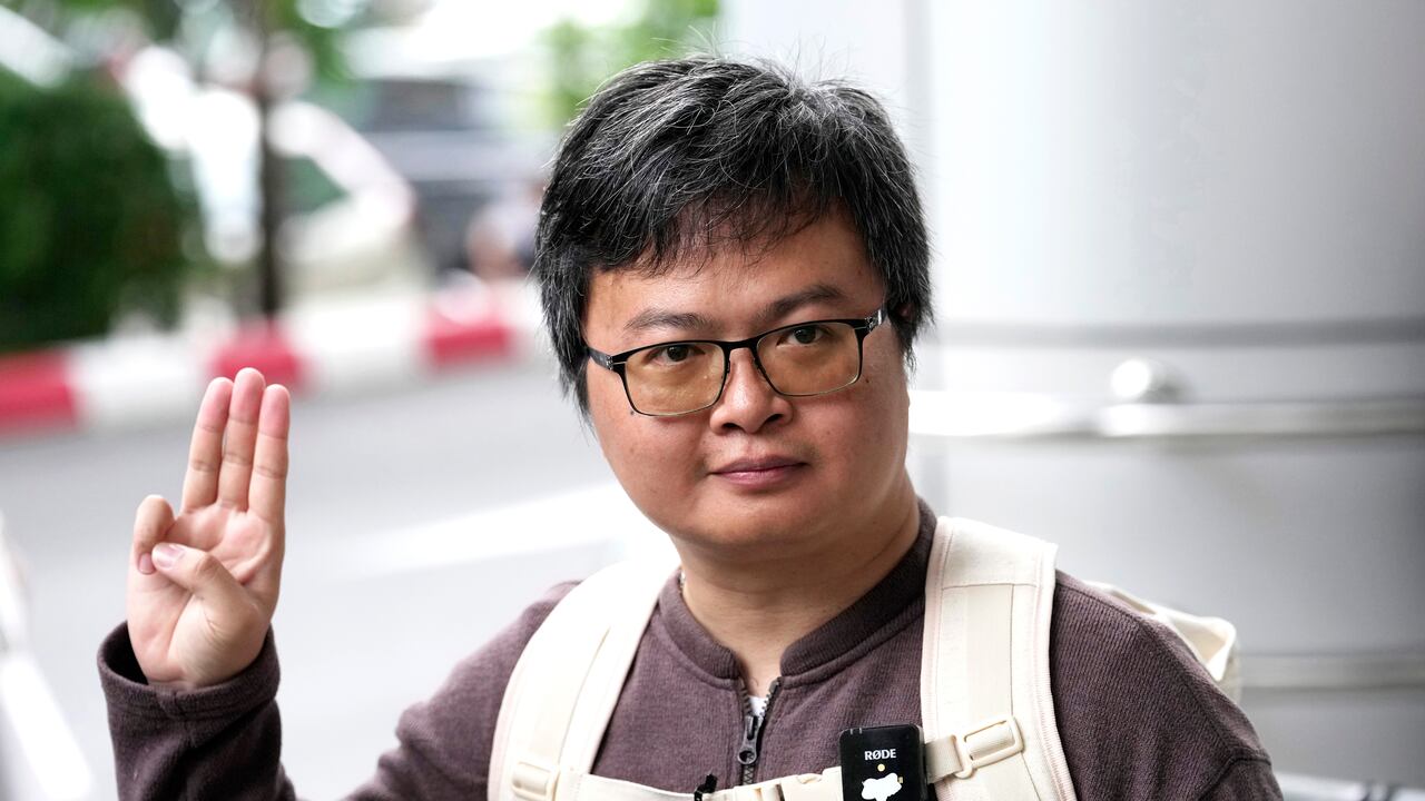 Arnon Nampa hace un gesto con tres dedos, un símbolo de resistencia, tras hablar con los medios a su llegada a la corte penal el martes 26 de abril de 2023. El destacado abogado de derechos humanos fue condenado a cuatro años de prisión por insultos a la corona. (AP Foto/Sakchai Lalit)