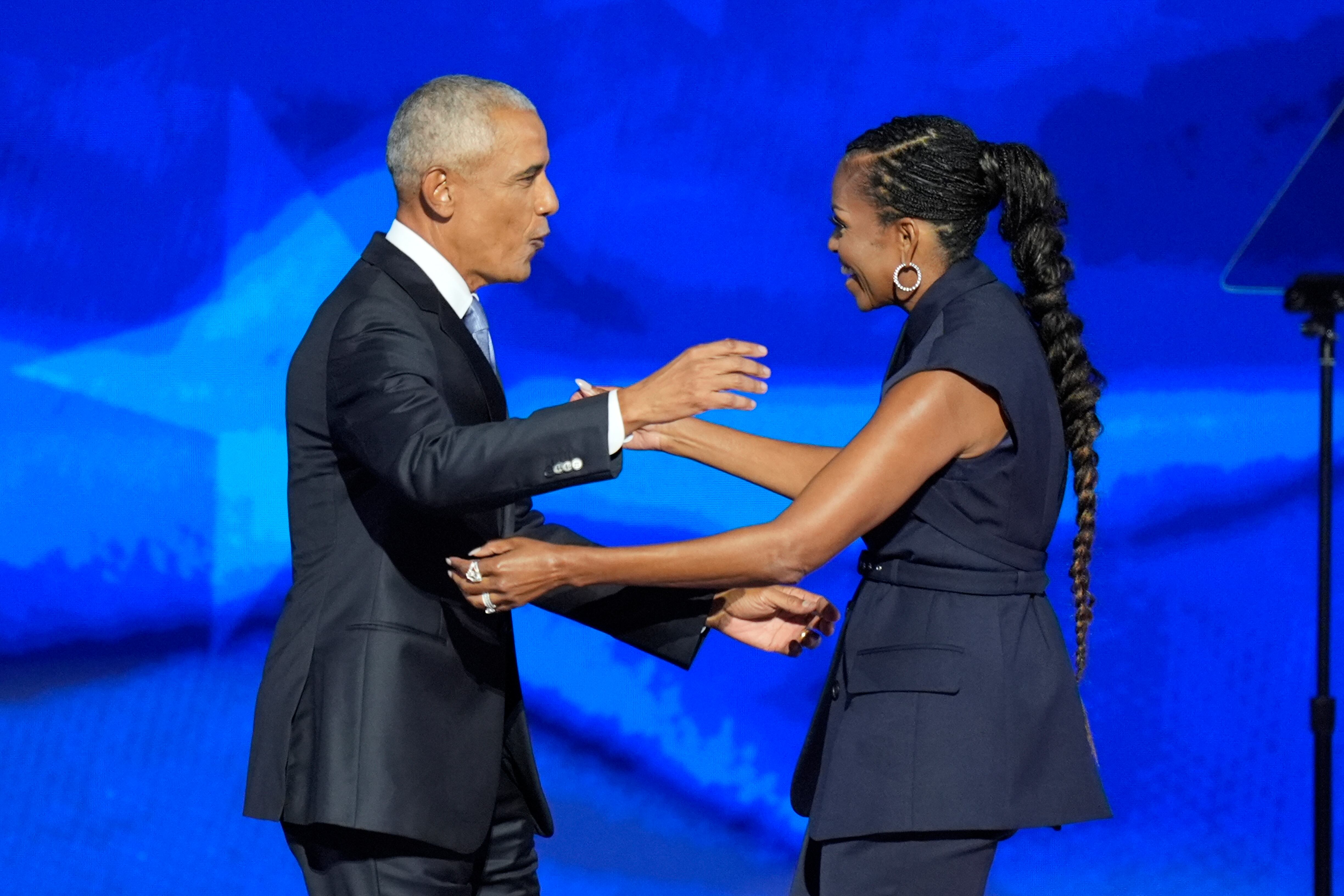 El expresidente Barack Obama, a la izquierda, y la exprimera dama Michelle Obama, a la derecha, se abrazan en la Convención Nacional Demócrata el martes 20 de agosto de 2024 en Chicago. (Foto AP/J. Scott Applewhite)