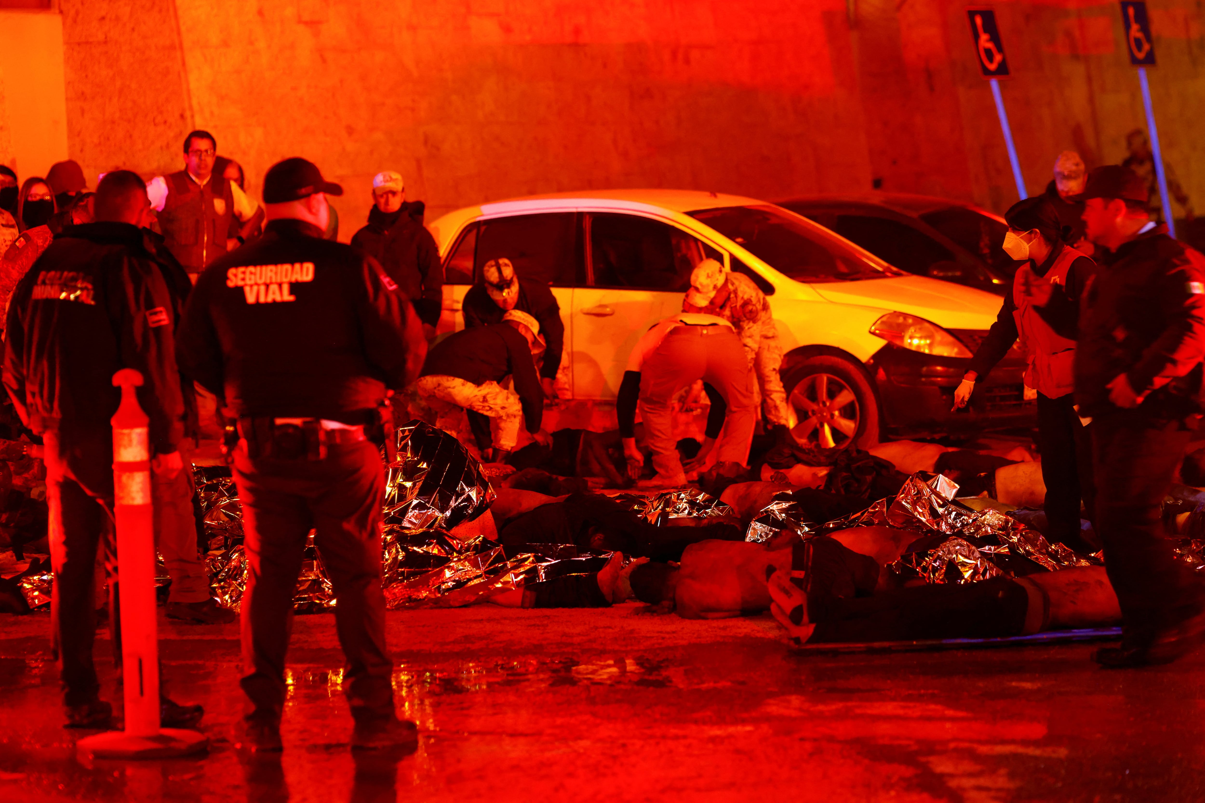 Autoridades y bomberos mexicanos sacan a migrantes heridos, en su mayoría venezolanos, del interior del edificio del Instituto Nacional de Migración (INM) durante un incendio, en Ciudad Juárez, México