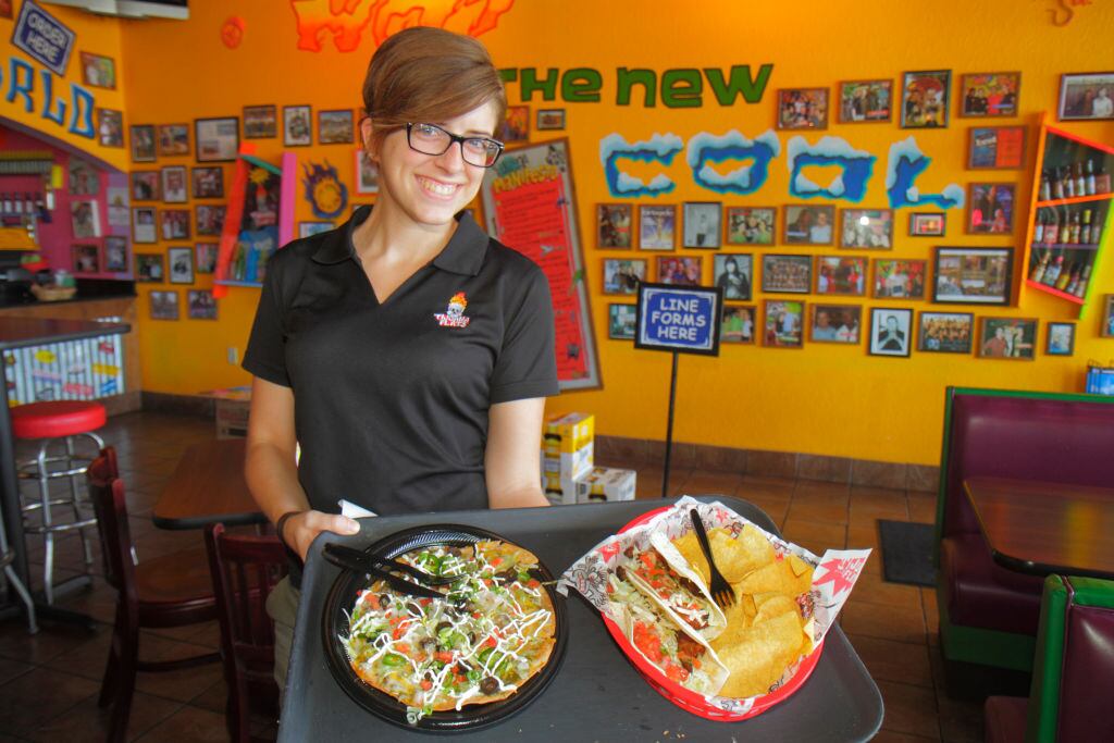 Una camarera sirviendo comida en comida Tex-Mex en Tijuana Flats.
