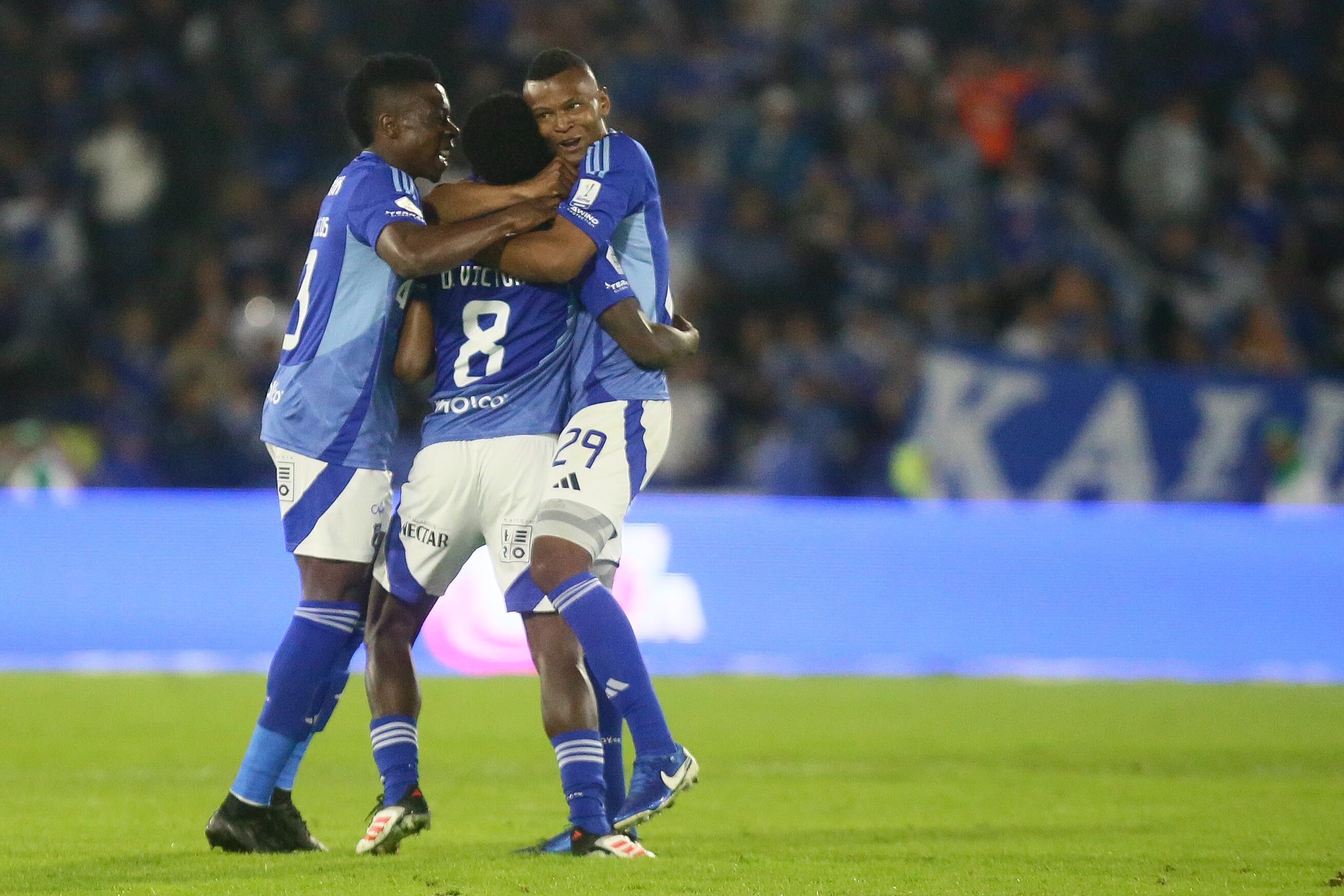 Helibelton Palacios, Dewar Victoria y Alex Moreno celebran un gol de Millonarios.