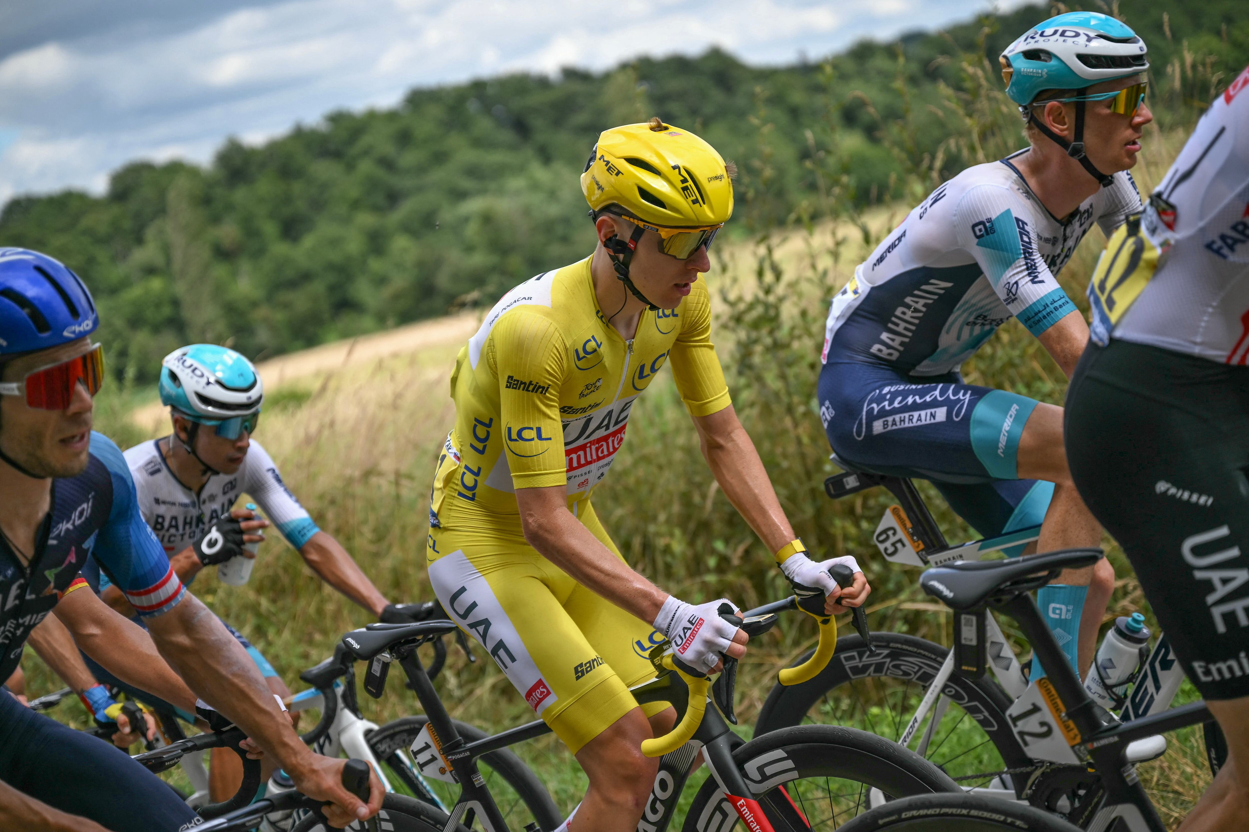 UAE Team Emirates team's Slovenian rider Tadej Pogacar wearing the overall leader's yellow jersey cycles with the pack of riders (peloton) during the 13th stage of the 111th edition of the Tour de France cycling race, 165,3 km between Agen and Pau, southwestern France, on July 12, 2024. (Photo by Marco BERTORELLO / AFP)