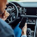 Hombre revisa su celular en el carro