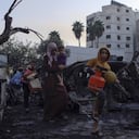 Los palestinos cargan sus pertenencias mientras salen del hospital de al-Ahli, que utilizaban como refugio, en la ciudad de Gaza.