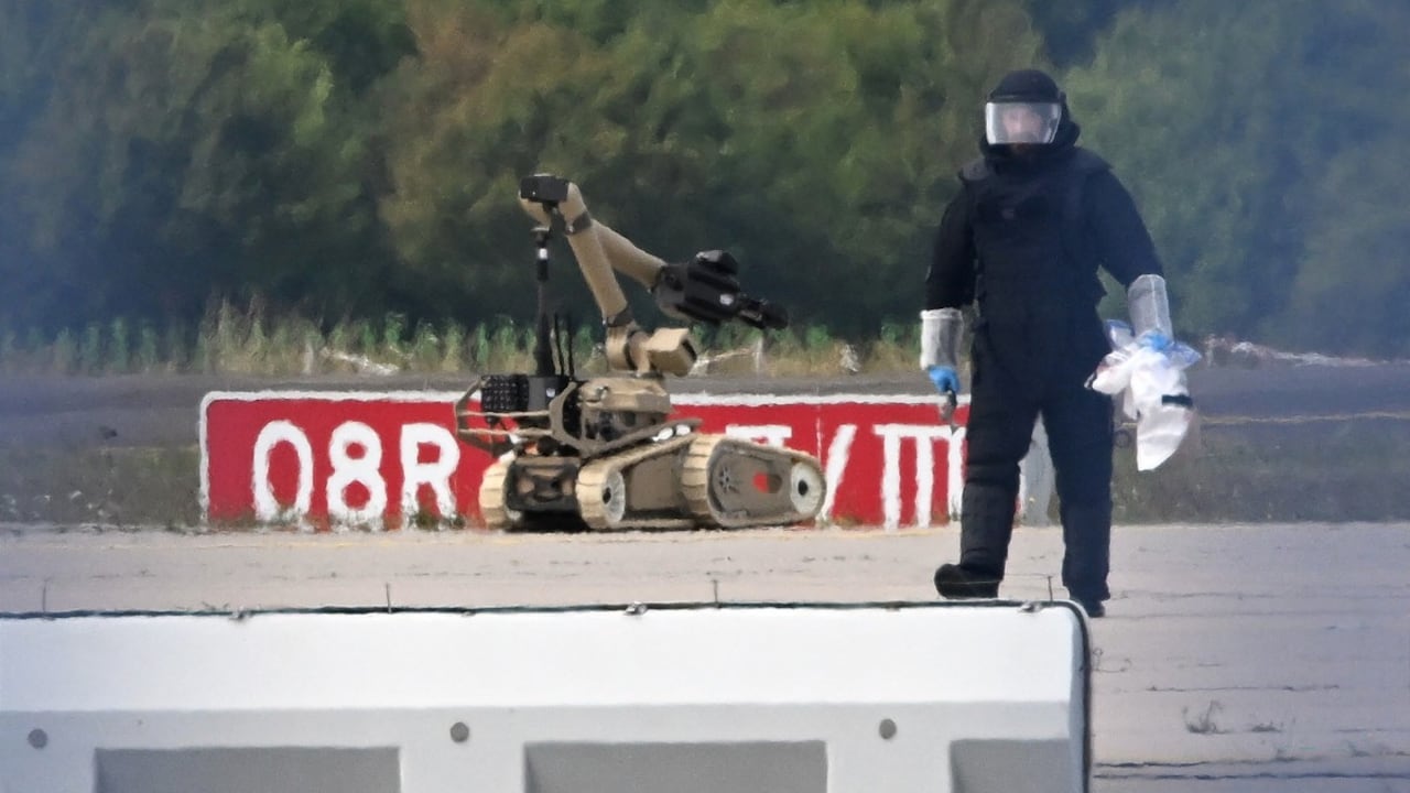 Un técnico forense trabaja junto a un robot de desactivación de explosivos cerca de un avión de carga ucraniano en el aeropuerto de Leipzig/Halle.