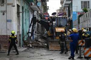 Rescuers work at an apartment block following a collapse, in Havana, on October 4, 2023. At least one person has died, a firefighter, and two others are missing after the collapse at an apartment block where around fifty people were living, emergency services and state media announced on Wednesday. A woman, a member of a fire brigade who had come to the scene to secure the area after the first collapse, died during rescue operations in a second collapse, a firefighter told AFP on condition of anonymity. Another firefighter and a 76-year-old resident of the building are still missing, according to the same source, who said that only the fa�ade of the building remained. (Photo by Yamil LAGE / AFP)