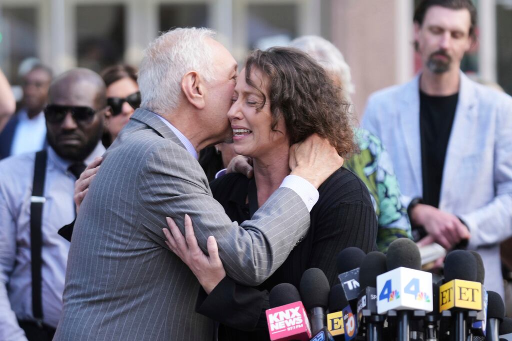 El abogado Mark Geragos (izquierda) abraza a Anamaria Baralt, prima de Erik y Lyle Menéndez, tras la audiencia de resentencia de los hermanos el martes 13 de mayo de 2025 en Los Ángeles. (Foto AP/Damian Dovarganes)