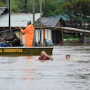 Agentes de policía revisan una casa mientras habitantes vadean una calle inundada por tormentas derivadas de un ciclón en Passo Fundo, en el estado de Rio Grande do Sul, Brasil, el lunes 4 de septiembre de 2023. (AP Foto/Diogo Zanatta-Futura Press)