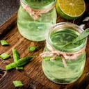 Healthy exotic detox drink, aloe vera or cactus juice with lime, on dark background copy space