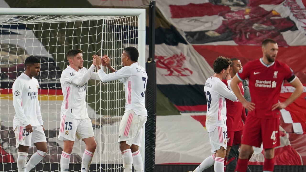 Federico Valverde (izquierda) y Eder Militao del Real Madrid celebran al término del partido contra Liverpool por los octavos de final de la Liga de Campeones, el miércoles 14 de abril de 2021. (AP Foto/Jon Super)