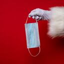 Papá Noel sosteniendo un tapabocas - Imagen de referencia