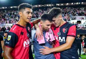 Leo Messi abrazando a dos jugadores de Newells tras el amistoso con el Inter Miami