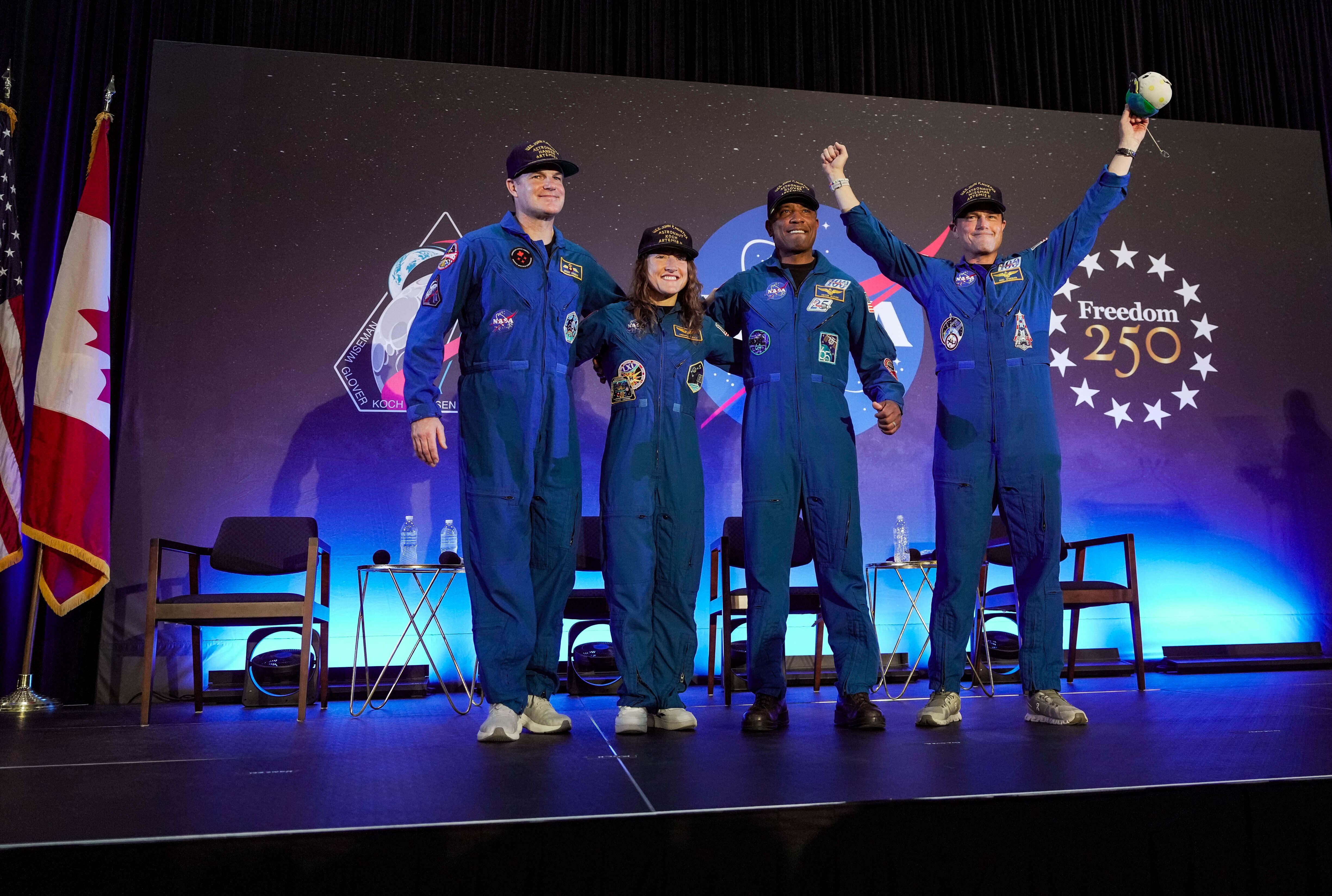 De izquierda a derecha: Jeremy Hansen, Christina Koch, Victor Glover y Reid Wiseman, la tripulación de Artemis II, fueron recibidos en el escenario durante una conferencia de prensa tras su misión en órbita alrededor de la Luna.