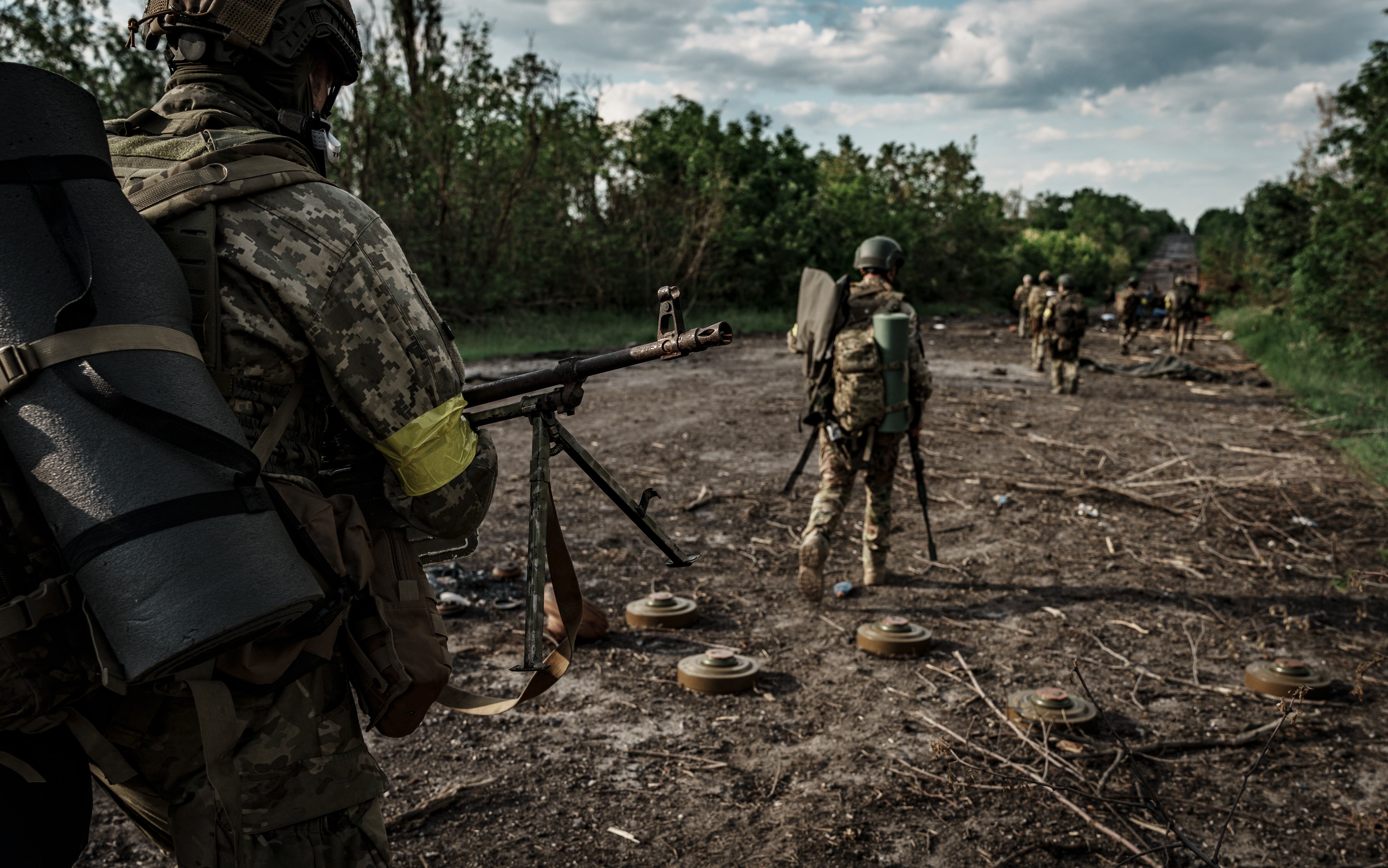 Militares ucranianos, equipados con armas, avanzan por la carretera entre minas antitanque y posiciones el 8 de junio de 2022 en el óblast de Járkov, Ucrania. Rusia lanzó una invasión a gran escala de Ucrania el 24 de febrero de 2022, desencadenando el mayor ataque militar en Europa desde la Segunda Guerra Mundial.