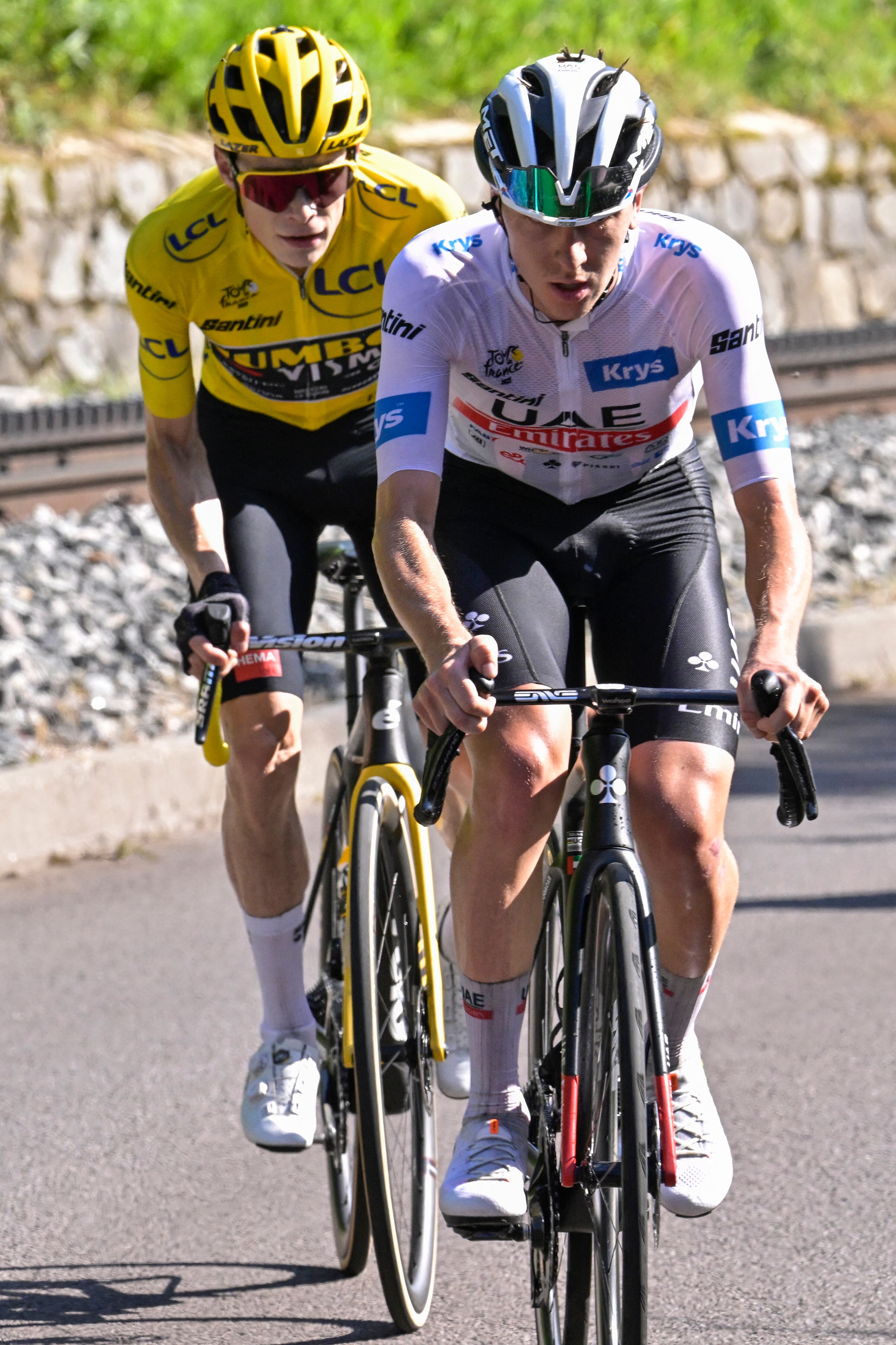 UAE Team Emirates' Slovenian rider Tadej Pogacar (R) wearing the best young rider's white jersey cycles ahead of Jumbo-Visma's Danish rider Jonas Vingegaard (L) wearing the overall leader's yellow jersey in the ascent of the Puy de Dome in the final kilometers of the 9th stage of the 110th edition of the Tour de France cycling race, 182,5 km between Saint-Leonard-de-Noblat and Puy de Dome, in the Massif Central volcanic mountains in central France, on July 9, 2023. (Photo by Bernard PAPON / POOL / AFP)