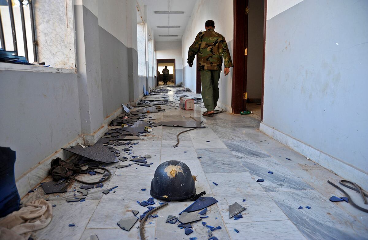 Un soldado del ejército libio camina por un edificio que militantes islámicos usaron como resguardo en Bengasi, Libia. Los enfrentamientos en Bengasi han cobrado la vida de por lo menos 210 personas. (AP)
