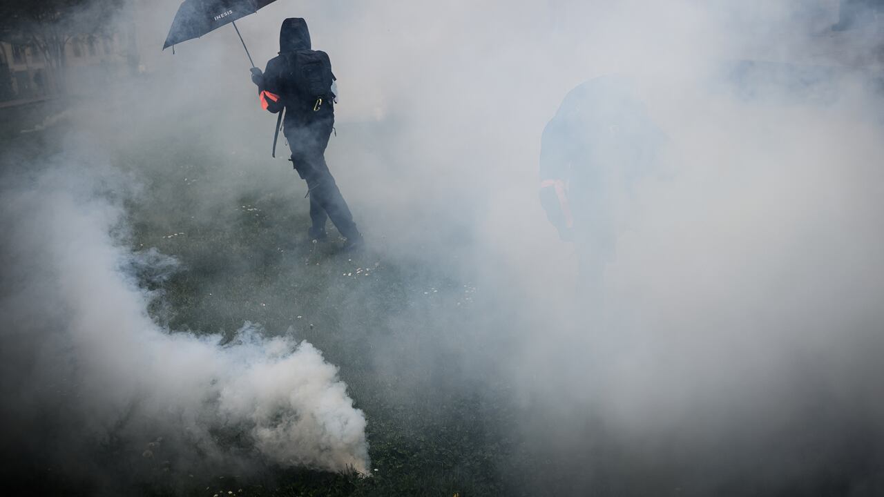 Un manifestante se para en nubes de gases lacrimógenos en medio de enfrentamientos con la policía antidisturbios durante una manifestación el Primero de Mayo (Día del Trabajo), para conmemorar el día internacional de los trabajadores, más de un mes después de que el gobierno aprobara una impopular ley de reforma de las pensiones en el parlamento, en Nantes. , noroeste de Francia.