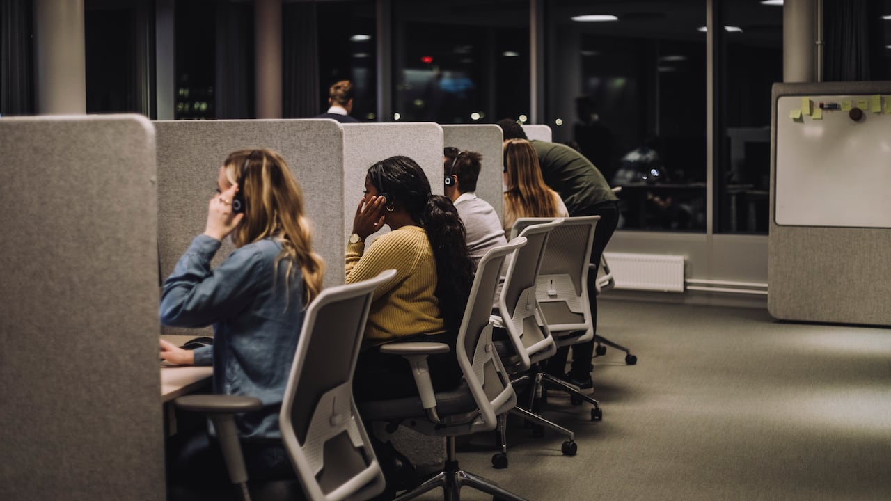 Multiracial team working side by side in illuminated call center