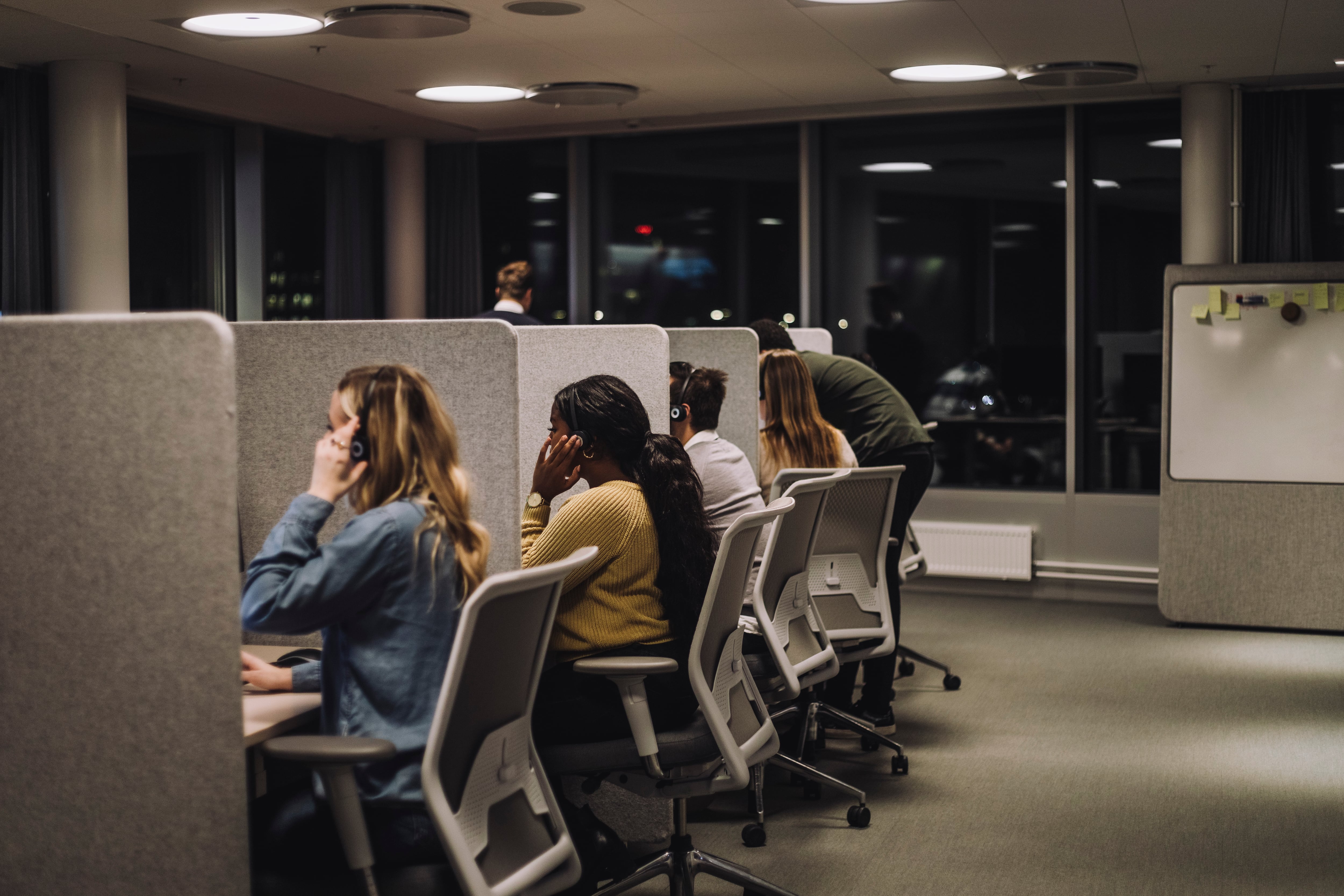 Multiracial team working side by side in illuminated call center