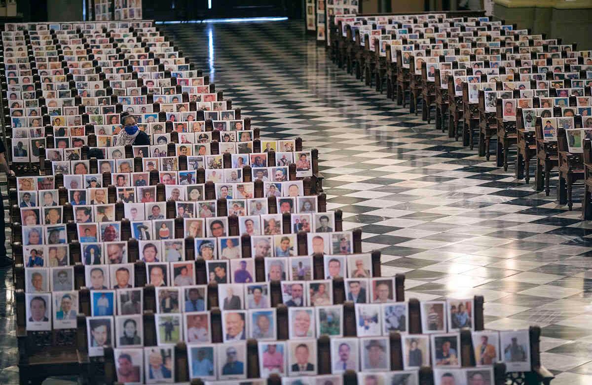 Esta mujer acompaña más de 4 mil retratos de personas que murieron debido a complicaciones por la covid-19. La foto fue tomada en la catedral de Lima, Perú, el 13 de junio. Foto: Rodrigo Abd/ AP