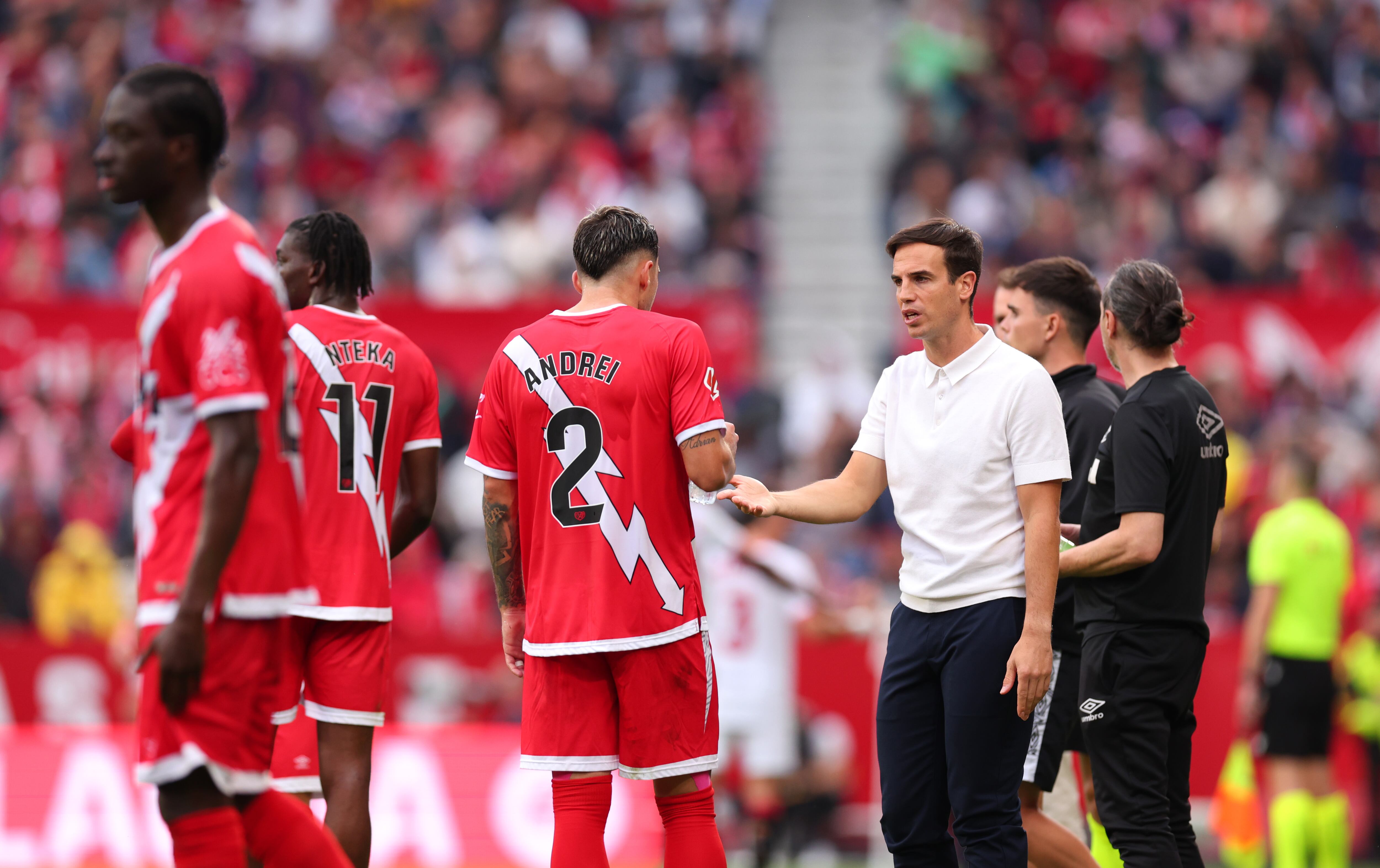 Iñigo Pérez, entrenador del Rayo Vallecano, interactúa con Andrei Ratiu del Rayo Vallecano durante el partido de LaLiga entre el Sevilla FC y el Rayo Vallecano en el Estadio Ramón Sánchez Pizjuán el 24 de noviembre de 2024 en Sevilla, España.