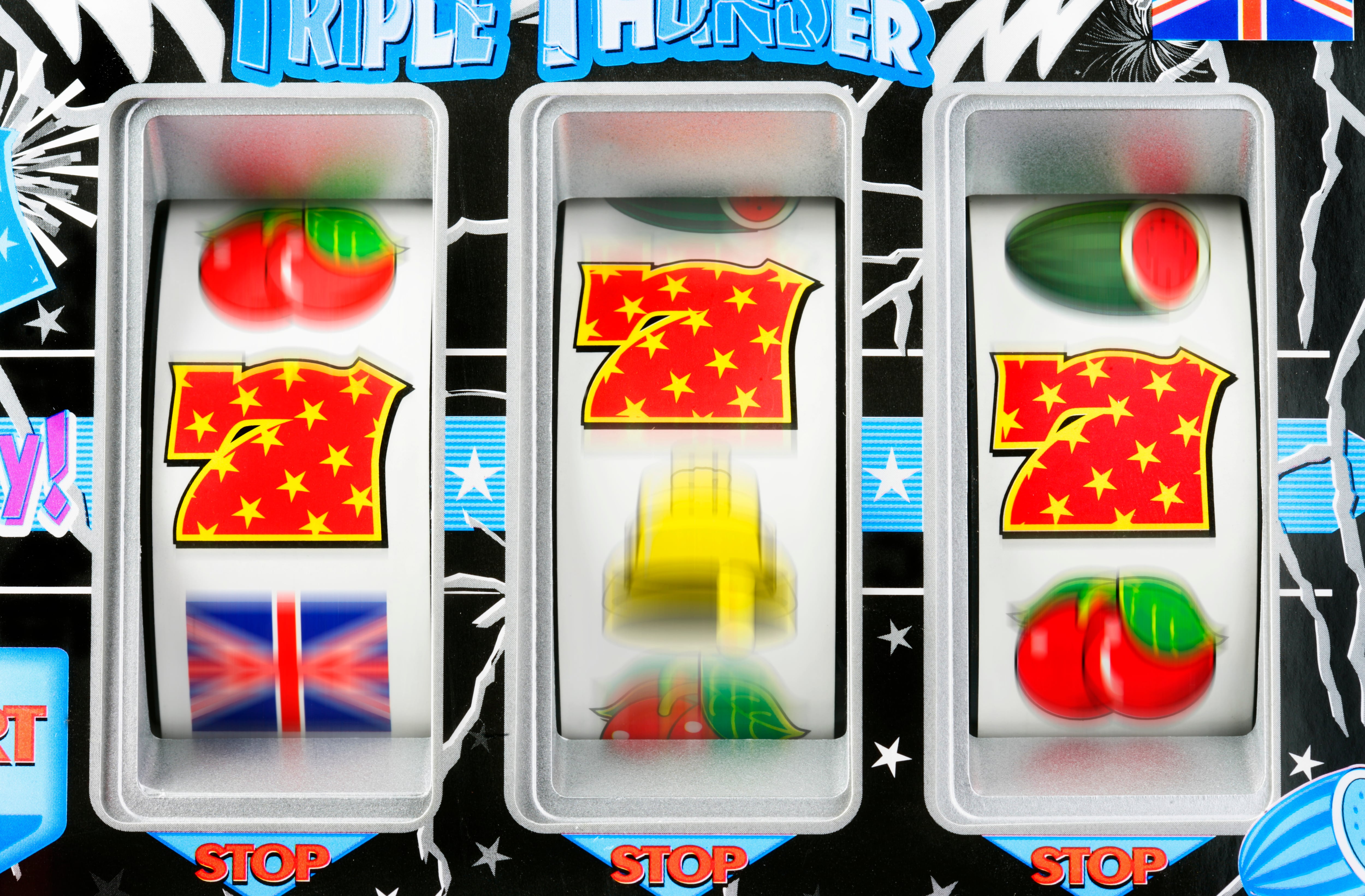 Fruit machine bars spinning to line of 7's, close-up (blurred motion)