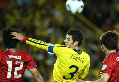 Pedro Franco (d) disputa el balón con Sang - Gi Min.