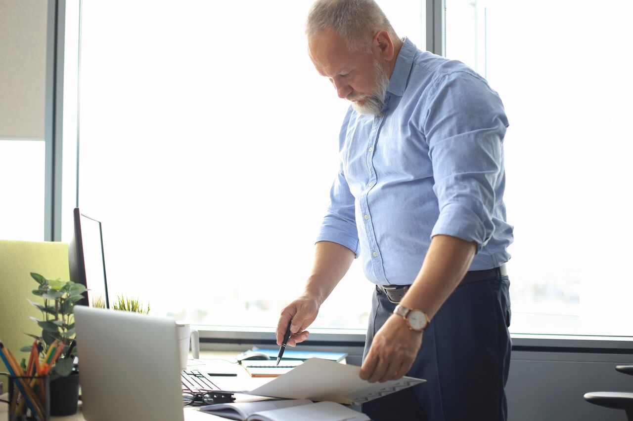 Elegante empresario maduro analizando datos mientras trabaja en la oficina