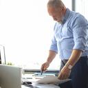 Elegante empresario maduro analizando datos mientras trabaja en la oficina