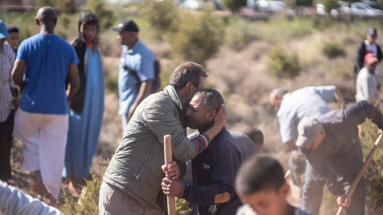 Las personas se consuelan mientras cavan tumbas para las víctimas del terremoto, en la aldea de Ouargane, cerca de Marrakech, Marruecos, el sábado 9 de septiembre de 2023.