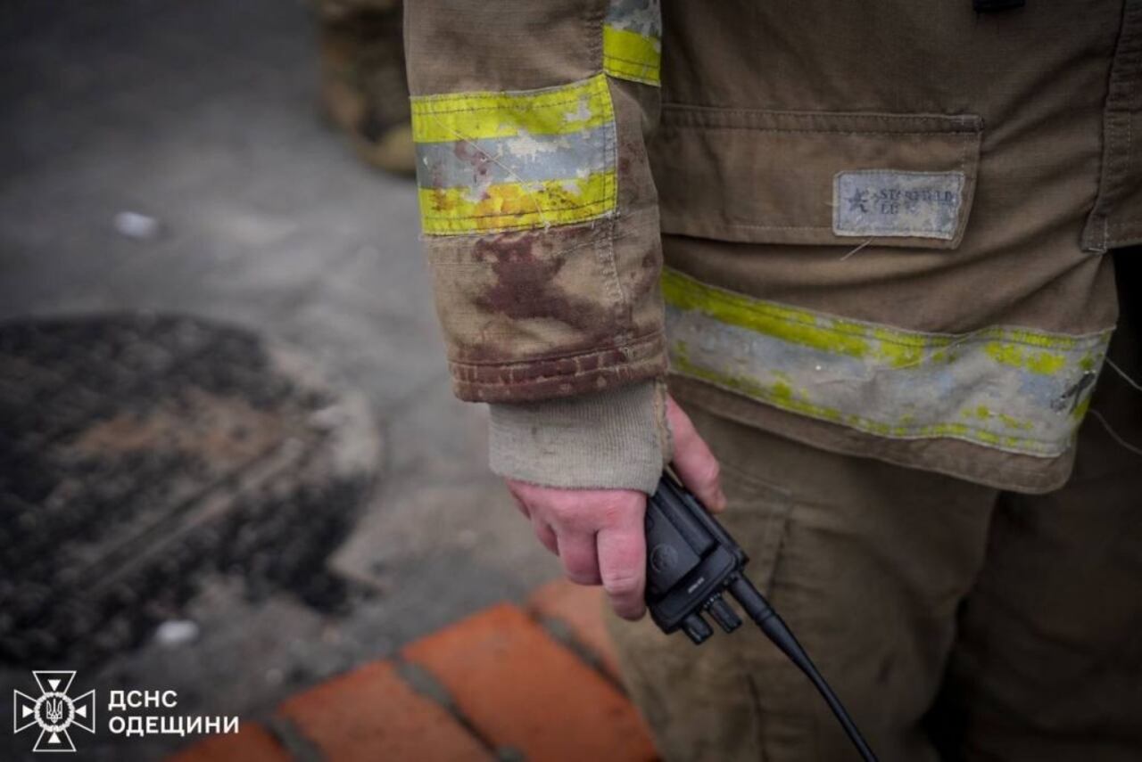 Los bomberos ucranianos extinguen el fuego en el lugar mientras los civiles esperan después de los ataques rusos dirigidos a diferentes lugares del país.