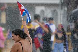 Un manifestante ondea una bandera cubana bajo la lluvia, el miércoles 14 de julio de 2021, en el barrio de La Pequeña Habana de Miami, mientras la gente se manifestaba en apoyo de las manifestaciones antigubernamentales en Cuba. (Foto AP / Wilfredo Lee)