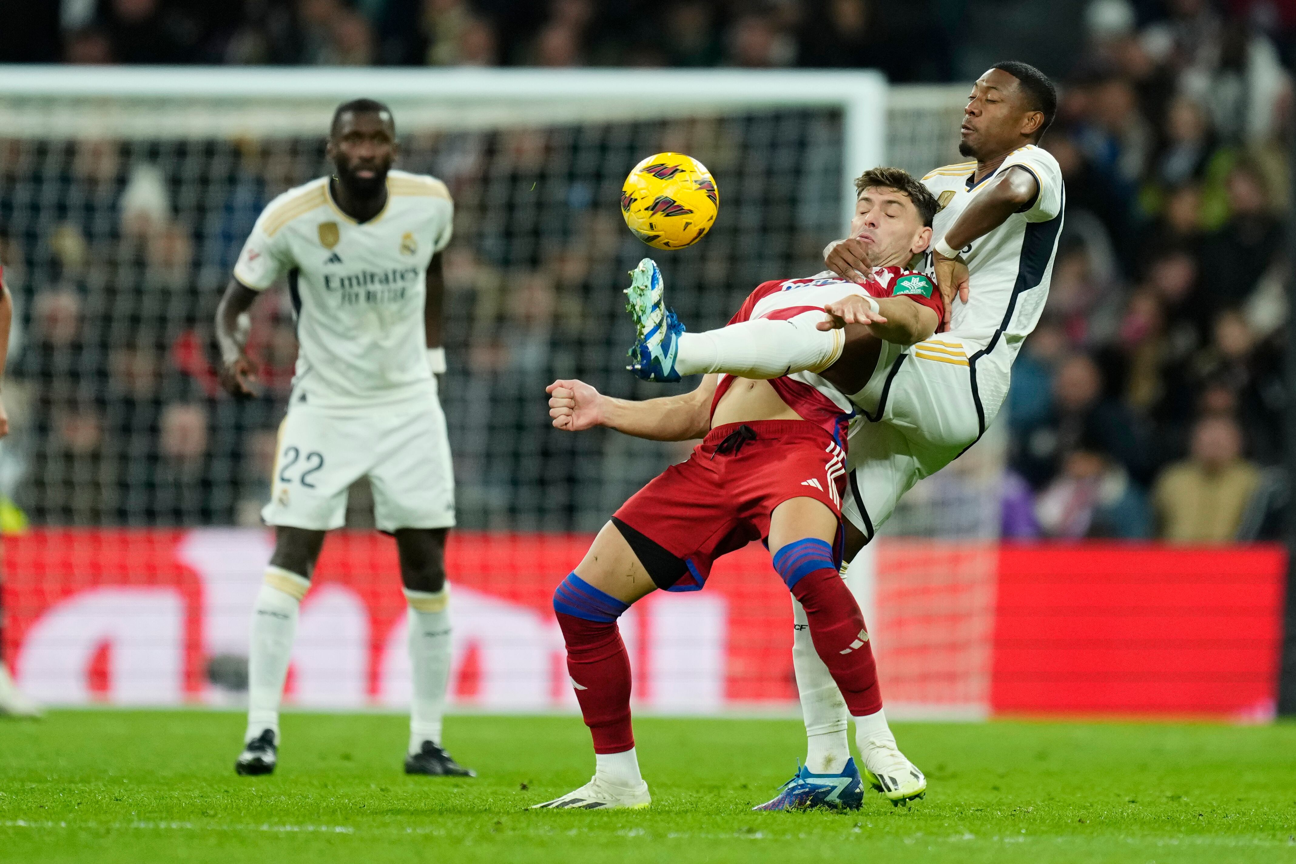 David Alaba, del Real Madrid, a la derecha, desafía el balón con Lucas Boye del Granada durante el partido de fútbol de la Liga española entre Real Madrid y Granada en el estadio Santiago Bernabeu en Madrid, España, el sábado 2 de diciembre de 2023. (Foto AP/José bretón)