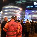 Los delegados revisan los pasaportes covid-19 de los fanáticos mientras hacen fila para ingresar al estadio antes del partido de fútbol de la Premier League entre Manchester City y Leeds en el Etihad Stadium
