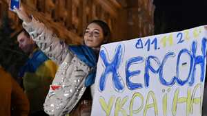 Una mujer sostiene un lema que dice "11/11/2022 - Kherson - Ucrania" en la plaza Maidan para celebrar la liberación de Kherson, en Kiev el 11 de noviembre de 2022, en medio de la invasión rusa de Ucrania. El presidente de Ucrania, Volodymyr Zelensky, dijo el 11 de noviembre que Jerson era "nuestra" después de que Rusia anunciara la finalización de su retirada de la capital regional, la única que Moscú capturó en casi nueve meses de combates.