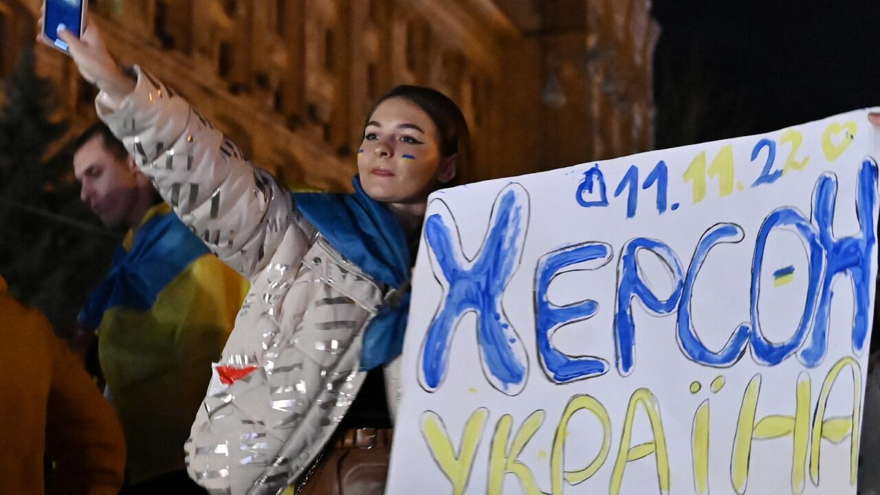 Una mujer sostiene un lema que dice "11/11/2022 - Kherson - Ucrania" en la plaza Maidan para celebrar la liberación de Kherson, en Kiev el 11 de noviembre de 2022, en medio de la invasión rusa de Ucrania. El presidente de Ucrania, Volodymyr Zelensky, dijo el 11 de noviembre que Jerson era "nuestra" después de que Rusia anunciara la finalización de su retirada de la capital regional, la única que Moscú capturó en casi nueve meses de combates.