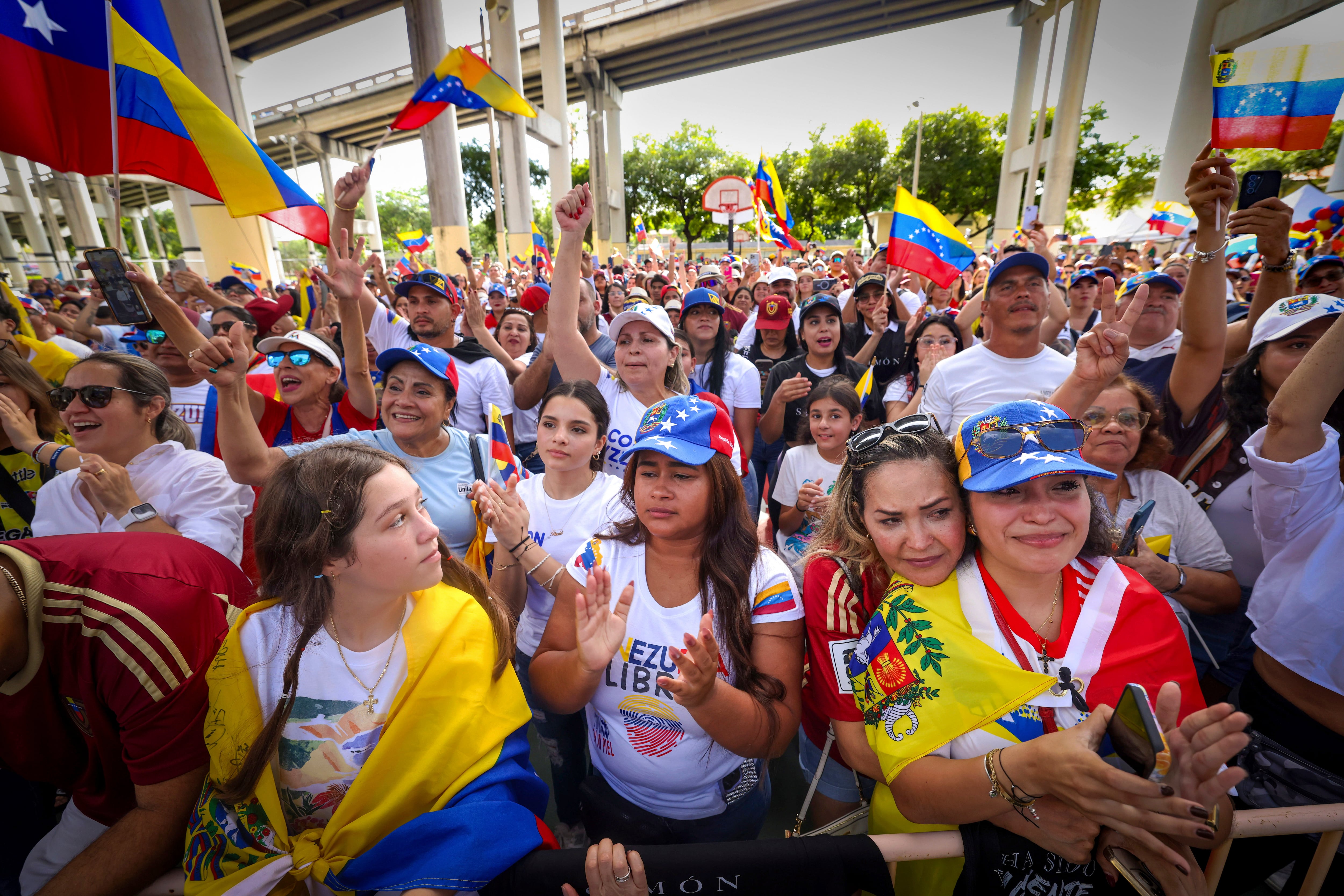 La gente canta y anima durante una canción venezolana en un mitin en el Gimnasio José Martí celebrado en apoyo de unas elecciones justas el día de las elecciones de Venezuela el domingo 28 de julio de 2024 en Miami. (Alie Skowronski/Miami Herald vía AP)
