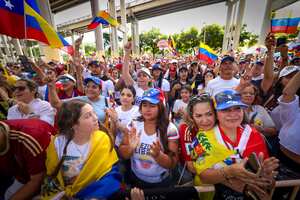La gente canta y anima durante una canción venezolana en un mitin en el Gimnasio José Martí celebrado en apoyo de unas elecciones justas el día de las elecciones de Venezuela el domingo 28 de julio de 2024 en Miami. (Alie Skowronski/Miami Herald vía AP)