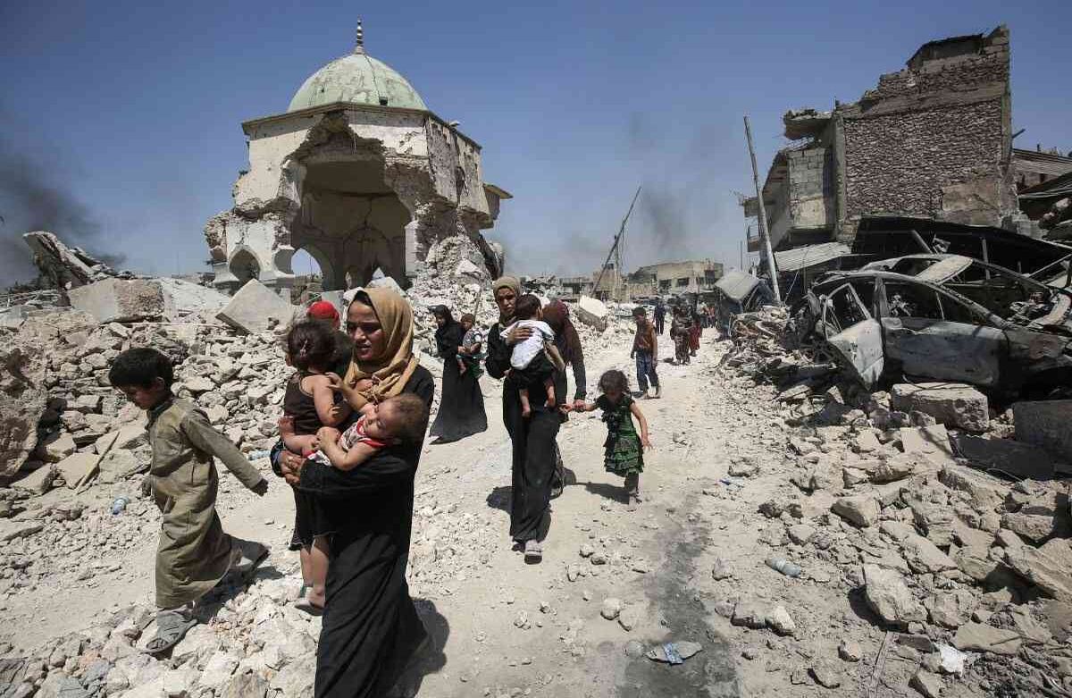 Los iraquíes caminan por la mezquita destruida de Al-Nuri mientras huyen de la Ciudad Vieja de Mosul durante la ofensiva de las fuerzas gubernamentales iraquíes para retomar la ciudad de los combatientes del grupo del Estado Islámico (IS). / AFP PHOTO / AHMAD AL-RUBAYE