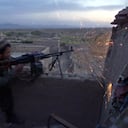 (ARCHIVOS) Esta foto de archivo tomada el 27 de octubre de 2001 muestra a un soldado de las fuerzas de la Alianza del Norte, opositoras a los talibanes, disparando contra posiciones de los talibanes en el frente de Sindejarat, a unos 45 kilómetros al norte de Kabul. - El presidente de Estados Unidos, George W. Bush, lanzó el 7 de octubre de 2001 su "guerra contra el terrorismo" en respuesta a los ataques del 11 de septiembre, con ataques aéreos contra Afganistán después de que el gobierno talibán protegiera a Osama bin Laden y su movimiento Al-Qaeda, que planeó 11 de septiembre. Después de dos décadas en Afganistán, la guerra más larga de Estados Unidos terminó con el rápido colapso el 15 de agosto de 2021 del gobierno en Kabul con los talibanes tomando el control una vez más. (Foto de Jack GUEZ / AFP)
