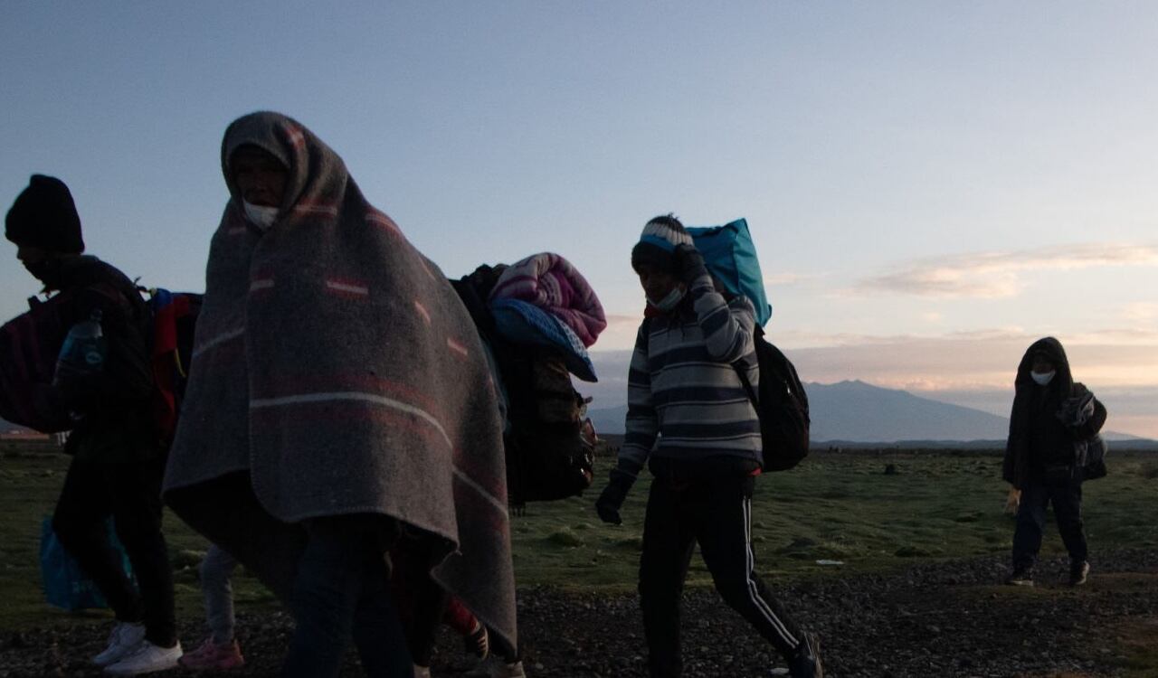 Varios migrantes, en su mayoría venezolanos, intentan cruzar la frontera entre Bolivia y Chile