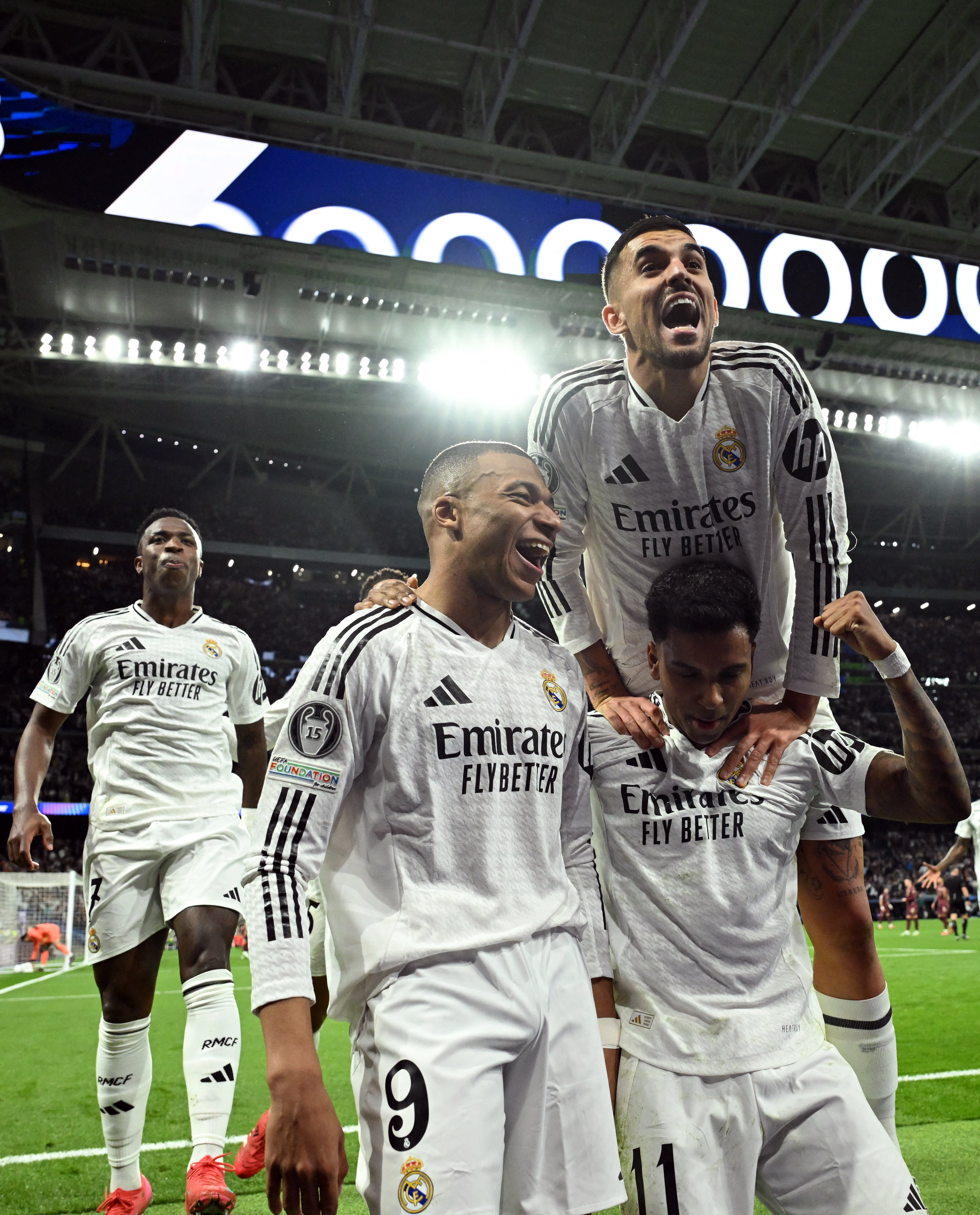 Real Madrid players celebrate their second goal scored by Real Madrid's French forward #09 Kylian Mbappe during the UEFA Champions League knockout phase play-off football match between Real Madrid CF and Manchester City at the Santiago Bernabeu stadium in Madrid on February 19, 2025. (Photo by JAVIER SORIANO / AFP)