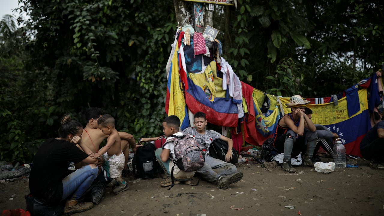 Migrantes sentados bajo un letrero que marca la frontera entre Panamá y Colombia durante su recorrido a través de la región del Darién, el martes 9 de mayo de 2023. La imagen fue parte de una serie tomada por los fotógrafos de The Associated Press Iván Valencia, Eduardo Verdugo, Félix Márquez, Marco Ugarte, Fernando Llano, Eric Gay, Gregory Bull y Christian Chávez que ganó el Premio Pulitzer 2024 en Fotografía de Reportaje. (AP Foto/Ivan Valencia)