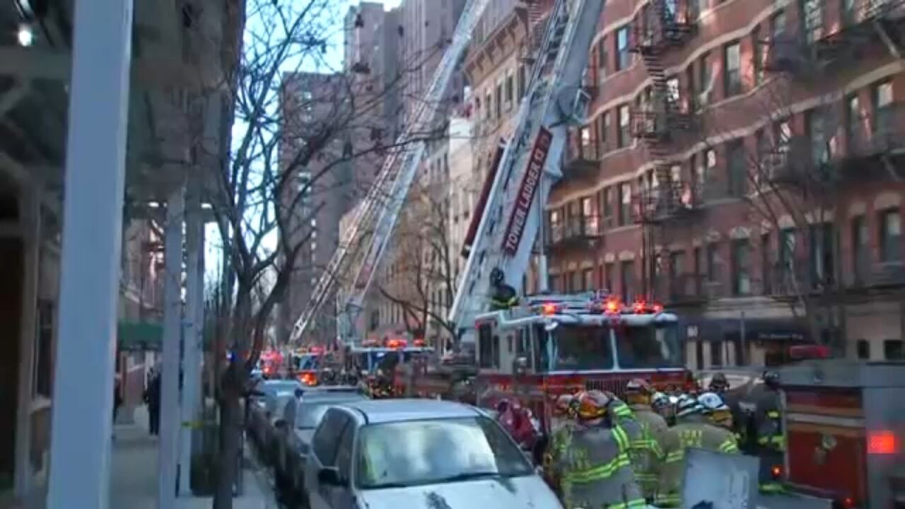 Bomberos con mangueras combatiendo incendio en edificio residencial del Upper East Side.