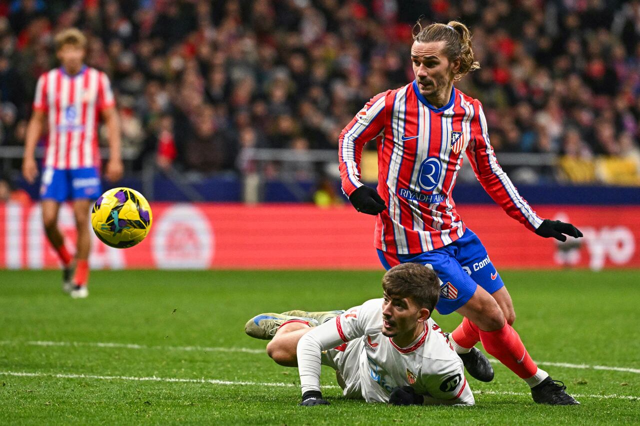 El delantero francés del Atlético de Madrid #07 Antoine Griezmann(R) es desafiado por el defensor español del Sevilla #04 Kike Salas durante el partido de fútbol de la liga española.