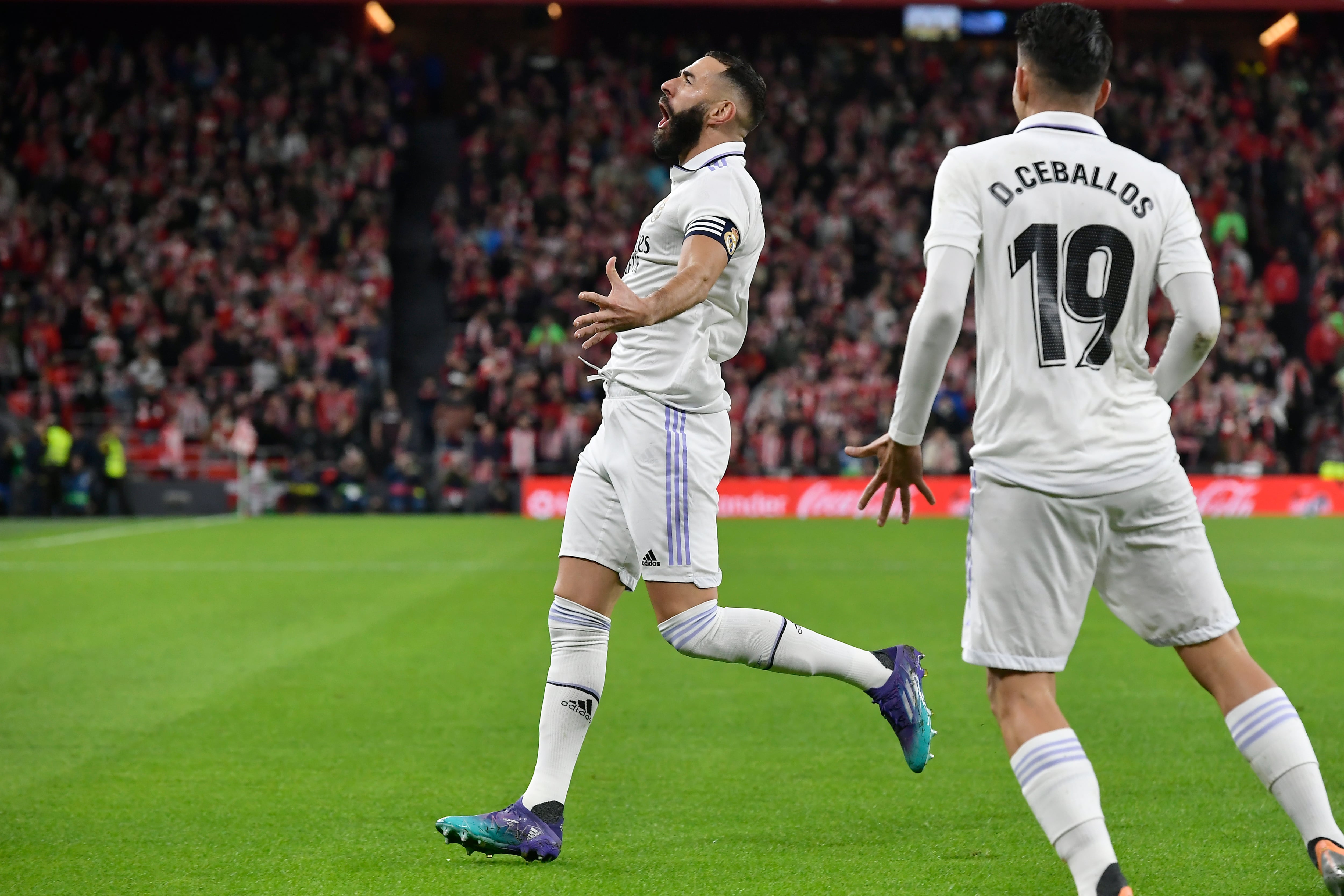 Real Madrid's Karim Benzema, left, celebrates with Dani Ceballos after scoring the opening goal during the Spanish La Liga soccer match between Athletic Club Bilbao and Real Madrid at the San Mames stadium in Bilbao, Spain, Sunday, Jan. 22, 2023. (AP Photo/Alvaro Barrientos)